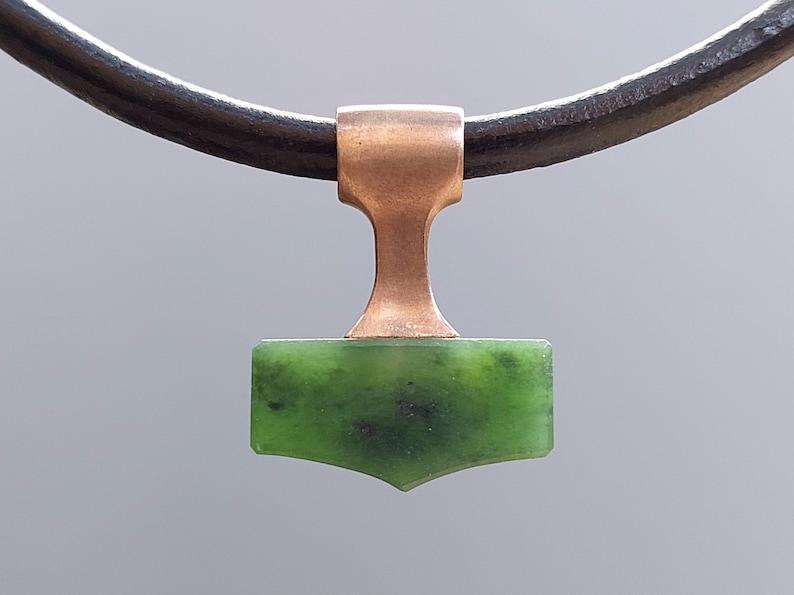 Bronze Mjolnir pendant with natural nephrite jade displayed on a leather cord.