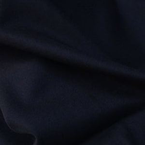 May include: A close-up of a dark blue fabric with a smooth texture. The fabric is folded and has a slight sheen.