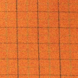 May include: Orange fabric with a brown and green plaid pattern.