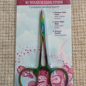 May include: 5 inch sewing and quilting needle grippers with titanium oxide finish. The grippers are rainbow colored and have large finger rings. The packaging says "Tooltron" and "Strong & Durable".