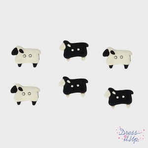 May include: Six sheep-shaped buttons in a mix of black and white. The buttons have a sheep silhouette with a black head and legs, and a white body. Each button has two small holes for sewing.