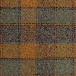 May include: A close-up of a brown, green, and orange plaid fabric. The fabric has a fuzzy texture and is measured with a ruler that reads "2001 Columbia".
