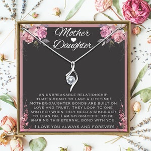 May include: A silver necklace with a clear crystal pendant and a card that reads "Mother Daughter" with a pink heart. The card has a floral design and the text "An unbreakable relationship that's meant to last a lifetime! Mother-daughter bonds are built on love and trust. They look to one another when they need a shoulder to lean on. I am so grateful to be sharing this eternal bond with you. I love you always and forever!"