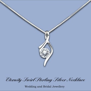 May include: A silver necklace with a swirl design and a clear crystal pendant. The necklace is on a blue background and the text "Eternity Swirl Sterling Silver Necklace" is below the image.  Wedding and Bridal Jewellery.