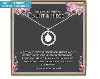 May include: A silver necklace with a pearl pendant in a circle design. The necklace is in a gift box with a message that reads "The bond between an aunt & niece" and "AUNTS AND NIECES SHARE AN UNBREAKABLE BOND THAT FLOURISHES ON FRIENDSHIP, LOVE, AND TRUST! HAVING YOU IN MY LIFE HAS ALWAYS BEEN ONE OF MY BIGGEST BLESSINGS. I LOVE YOU SO MUCH!"