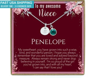 May include: A silver necklace with a personalized initial charm and a green crystal charm comes in a burgundy box with a floral design and the text "To my awesome Niece Penelope".