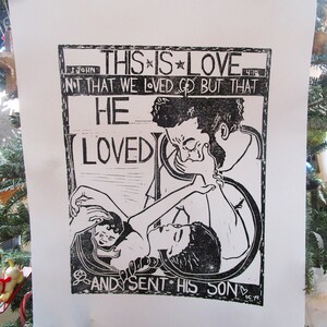 May include: Black and white print of a religious image with the text "This is Love 1 John 4:10 Not that we loved God but that He Loved Us and sent His Son".