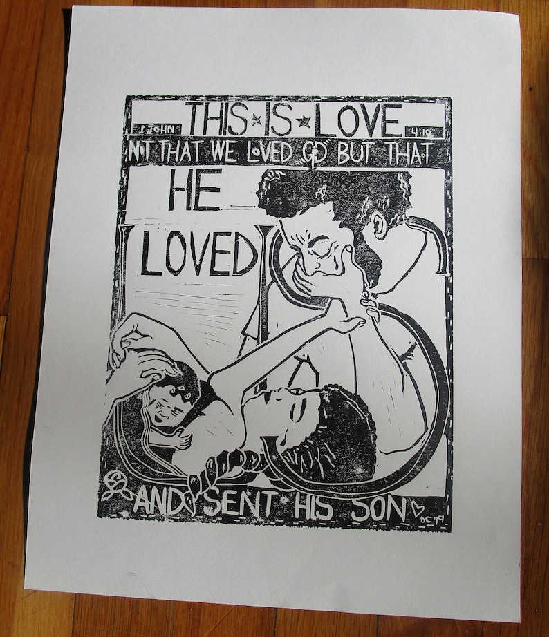 May include: Black and white woodcut print of a couple embracing. The print features the text "This is Love, Not that we loved God but that He Loved and sent His Son."