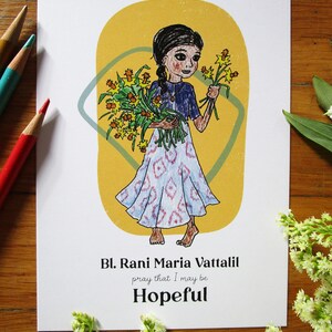 May include: A colorful illustration of a woman holding a bouquet of yellow flowers. The text reads "Bl. Rani Maria Vattalil pray that I may be Hopeful".