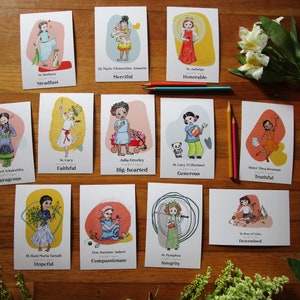 Puede incluir: Doce tarjetas ilustradas con diferentes santas y figuras religiosas femeninas. Cada tarjeta tiene una ilustración colorida de una mujer y una palabra que describe su rasgo de carácter. Las palabras incluyen Steadfast, Merciful, Honorable, Courageous, Faithful, Big-hearted, Generous, Truthful, Hopeful, Compassionate, Integrity, and Determined.