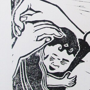 May include: Black and white woodcut print of a hand holding a sleeping child. The child is wrapped in a blanket and has a peaceful expression on their face.