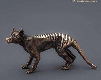 May include: Bronze sculpture of a Tasmanian tiger, also known as a thylacine, in a running pose. The sculpture is detailed with stripes and has a realistic appearance.