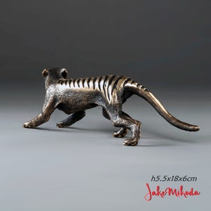 May include: Bronze sculpture of a Tasmanian tiger, also known as a thylacine, in a walking pose. The sculpture is 5.5 inches tall and 18 inches long. The sculpture is by artist Jake Mikoda.