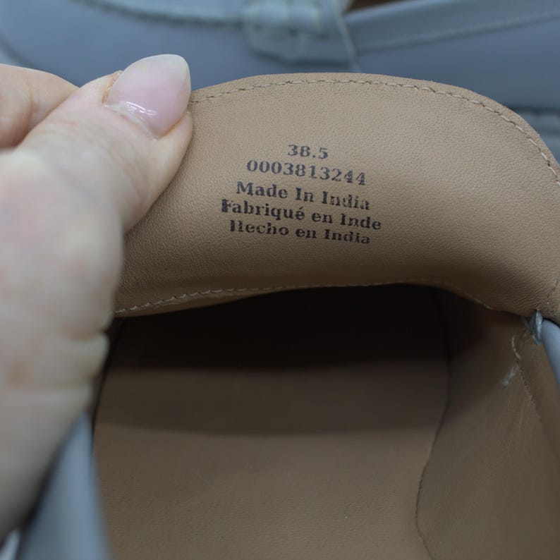 Pu&ograve; includere: Primo piano dell'interno di una scarpa azzurra. L'interno della scarpa &egrave; beige, con il testo "38.5", "0003813244", "Made In India", "Fabriqu&eacute; en Inde" e "Hecho en India".