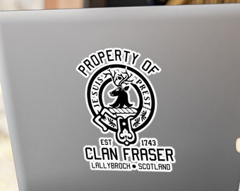 Könnte beinhalten: Schwarz-weißer Aufkleber mit einem Wappen, das einen Hirsch zeigt, und dem Text "PROPERTY OF", "JESUS", "PREST", "EST 1743", "CLAN FRASER", "LALLYBROCH" und "SCOTLAND".