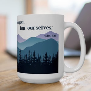 以下が含まれることがあります： 青い山と紫色の山が描かれた白いセラミックマグカップ。"私たちは征服することができます。しかし、自分自身を." -ホール夫人