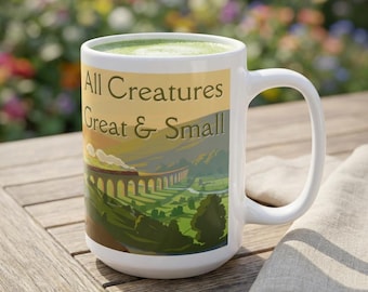 Könnte beinhalten: Ein weißer Keramikbecher mit einer aufgedruckten Illustration eines Zuges, der bei Sonnenuntergang über ein steinernes Viadukt in einem grünen Tal fährt. Der Text All Creatures Great & Small ist dunkel über der Landschaftsszene aufgedruckt.