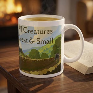 May include: A white ceramic mug featuring a printed landscape illustration of rolling green hills, a stone wall, and a vintage car. The text All Creatures Great & Small is printed in dark brown lettering across the center of the scenic design.