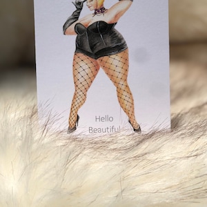 May include: A hand-drawn illustration of a woman wearing a black corset, fishnet stockings, and a top hat. The woman is holding the top hat with one hand and has a playful expression on her face. The text "Hello Beautiful!" is written below the woman.