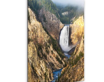 May include: A scenic photograph of a waterfall cascading into a river, surrounded by canyon walls and evergreen trees. The image captures the natural beauty of a landscape with a bright, sunny atmosphere.
