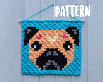 May include: Crochet pattern for a pug dog wall hanging. The pattern is made with different colored yarn, including brown, black, white, and pink. The pattern is framed with a turquoise blue border.