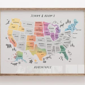 May include: A framed map of the United States with each state colored in a different pastel hue. The map is labeled "Jenny & Adam's Adventures" and includes small illustrations of animals and trees. The frame is made of light-colored wood.