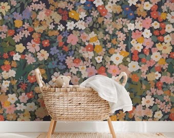 May include: A wicker bassinet with a teddy bear inside, set against a wall covered in a floral wallpaper with a dark background and colorful flowers.
