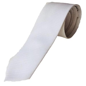 May include: A white silk tie with a subtle texture. The tie is rolled up and ready to be worn.