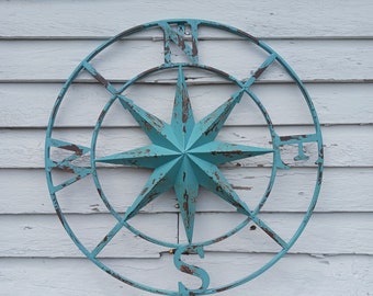 Metal Compass With Teal Rusted Details. 24 inches wide by 24 inches tall.