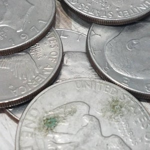 May include: Close-up of a stack of silver US half dollar coins. The coins feature the profile of a bald eagle with outstretched wings and the words "United States of America" and "E Pluribus Unum".