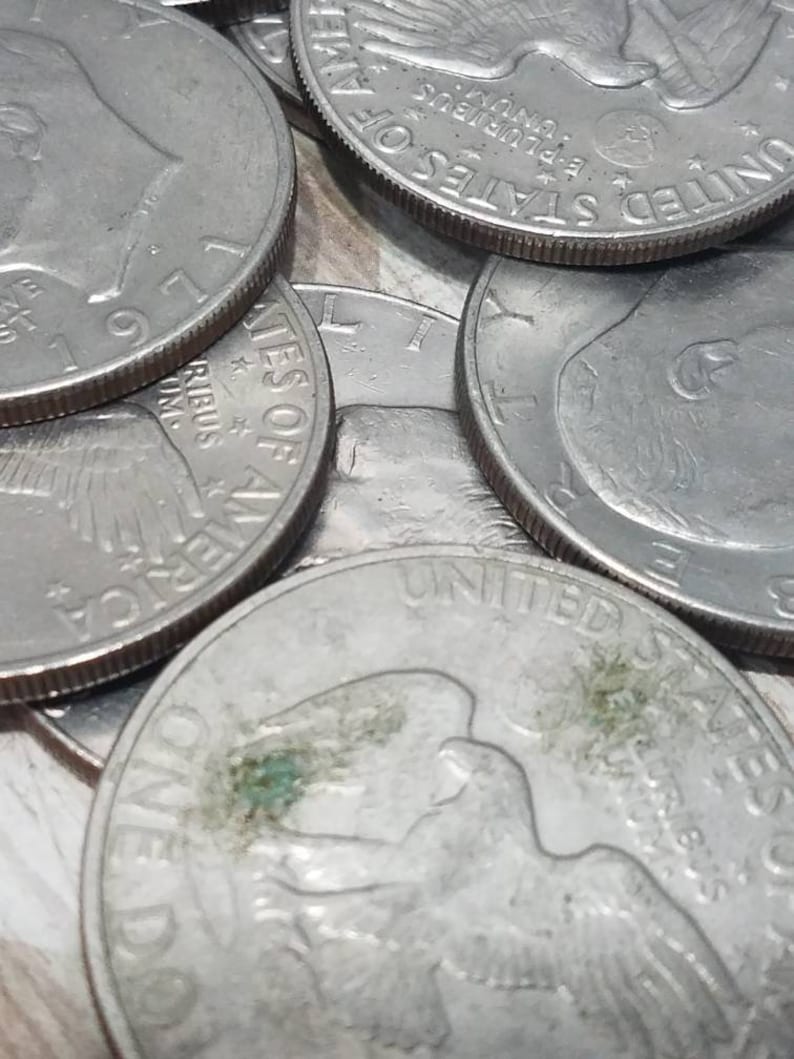 May include: Close-up of a stack of silver US half dollar coins. The coins feature the profile of a bald eagle with outstretched wings and the words "United States of America" and "E Pluribus Unum".