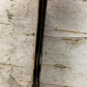 May include: A close-up of a vintage pocket knife. The knife has a dark brown handle and a pointed blade. The blade is extended, revealing its sharp edge. The knife appears to be well-worn, suggesting it has been used over time.