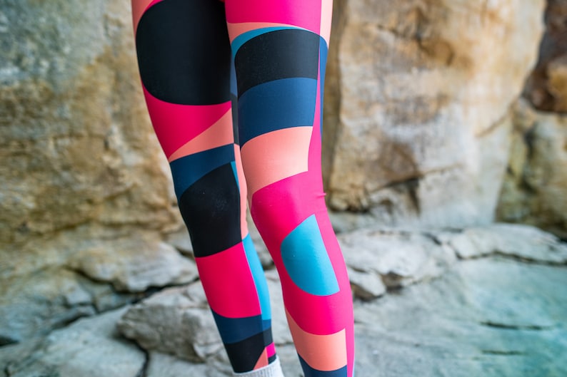 Op de afbeelding: Een legging met een geometrisch patroon in tinten roze, blauw en zwart.