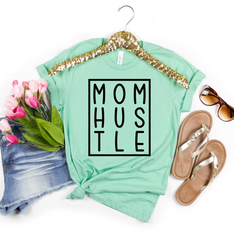 May include: A light green t-shirt with the text "MOM HUSTLE" in a black box.