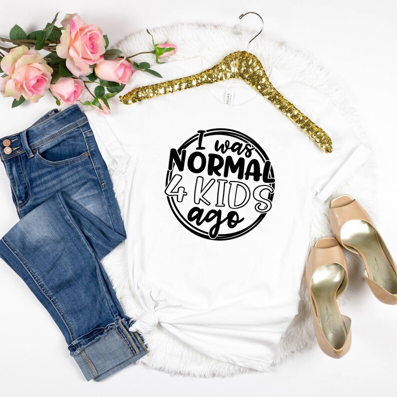 May include: White t-shirt with black text that reads "I was normal 4 kids ago" in a circle.