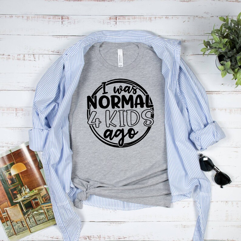 May include: A gray t-shirt with a black circle graphic that says "I was normal 4 kids ago".