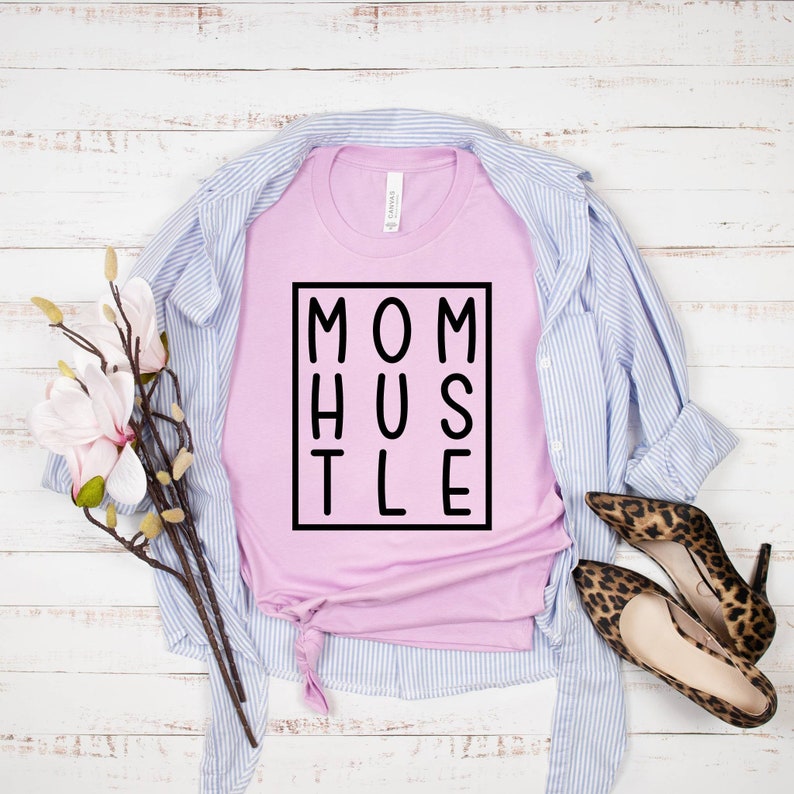 May include: A pink t-shirt with the text "MOM HUSTLE" in a black box.