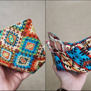May include: A fabric bowl with a geometric pattern in shades of blue, red, yellow, and brown. The bowl is folded and ready to be used.