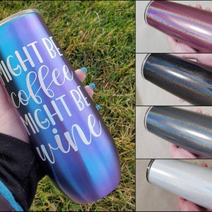 May include: A stainless steel tumbler with a iridescent finish. The tumbler has the text "Might be coffee might be wine" printed on it.
