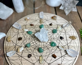 May include: A wooden crystal grid with a geometric design, adorned with various crystals in clear, green, and brown hues. The crystals are arranged on the grid, creating a visually appealing display for spiritual practices.