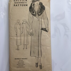 May include: Vintage sewing pattern titled "The New Excella Beginner's Pattern." The pattern features an illustration of a woman in a long coat with a fur collar. The pattern is size 44 and lists suitable materials like duvetyn and velvet.