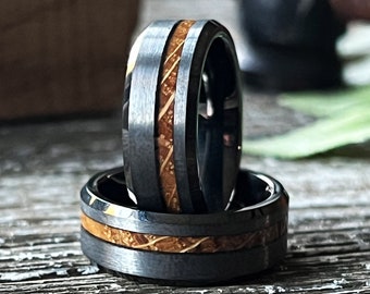 May include: Two black tungsten carbide rings with a wood inlay. The rings are stacked on top of each other.
