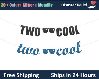 Può includere: Uno striscione con le parole "TWO COOL" in nero e "two cool" in glitter blu, ognuna con occhiali da sole. Lo striscione è infilato su un filo sottile. Lo striscione superiore ha uno sfondo blu scuro con il testo "20+ Colors Glitter & Metallic" e "Disaster Relief".