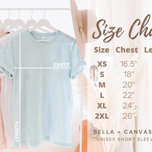 Puede incluir: Tabla de tallas para una camiseta de manga corta unisex, que muestra las medidas de pecho y largo en pulgadas para las tallas XS, S, M, L, XL y 2XL. La tabla est&aacute; impresa sobre un fondo rosa y blanco con un sombrero marr&oacute;n y una guitarra en el fondo.