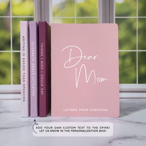 Puede incluir: Un conjunto de cuatro diarios de color rosa y morado con el texto "Dear Mom" en la portada. Los lomos de los diarios est&aacute;n en blanco y se pueden personalizar con texto personalizado. El texto "Letters from Christina" est&aacute; impreso debajo del t&iacute;tulo.