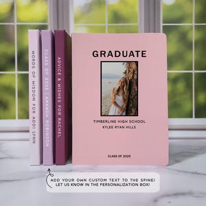 May include: Three pink, purple, and maroon notebooks with the text "ADVICE & WISHES FOR RACHEL", "CLASS OF 2025 | AMANDA ROBINSON", and "WORDS OF WISDOM FOR ADDI LYNN" on the spines. The front cover of the pink notebook has the text "GRADUATE" in black, a photo of a young woman in a white dress, and the text "TIMBERLINE HIGH SCHOOL", "KYLEE RYAN HILLS", and "CLASS OF 2025".