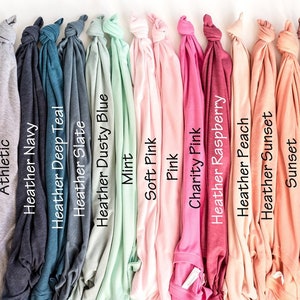 Puede incluir: Una variedad de colores de camisetas, incluyendo negro, blanco, gris jaspeado, ceniza, deportivo, azul marino jaspeado, azul teal jaspeado, pizarra jaspeado, azul polvoriento jaspeado, menta, rosa suave, rosa, rosa caridad, frambuesa jaspeado, melocot&oacute;n jaspeado, atardecer jaspeado, atardecer, malva jaspeado, malva, orqu&iacute;dea jaspeado, marr&oacute;n jaspeado y marr&oacute;n.