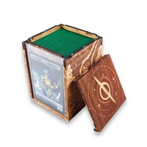 May include: A wooden card storage box with a removable lid. The box is stained brown with etched designs and a green interior. A card is visible in a clear sleeve on the front. The lid features a circular design.