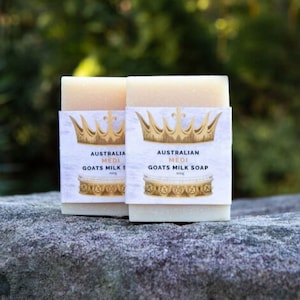 Pode incluir: Duas barras de sabonete de leite de cabra com um rótulo branco com uma coroa dourada e o texto "Australian Medi Goats Milk Soap".