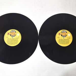 Peut inclure: Deux disques vinyles noirs avec des étiquettes jaunes et rouges. Les étiquettes portent l'inscription "Music Society" et "True Love - Various Artists". Les disques sont circulaires et ont une finition brillante, pour les mélomanes et collectionneurs.